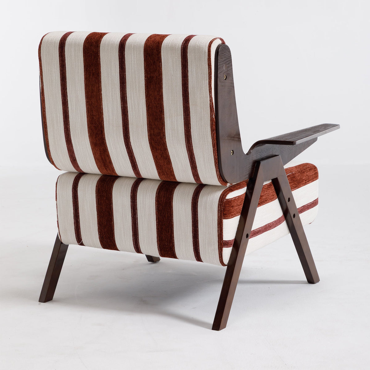 A mid-century modern lounge chair with a striped fabric upholstery in brown and cream, supported by a dark wood frame with angled legs and a side table extension.