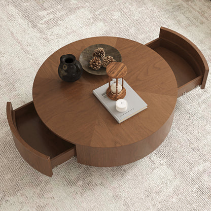 A round wooden coffee table with two pull-out storage drawers, shown on a textured light gray rug with decorative items on top.