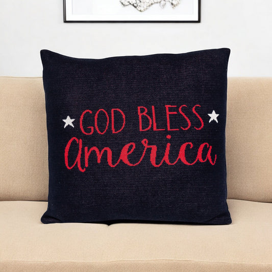 Black pillow with 'God Bless America' text on a beige couch