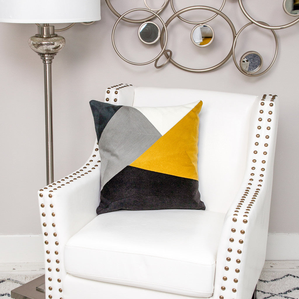 Decorative pillow with geometric design on a white armchair in a stylish room.