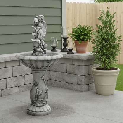 Decorative stone bird bath with angel sculpture on a patio