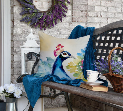 Decorative pillow with peacock design on a bench with a wreath and flowers in the background.