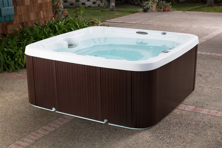 Hot tub with brown exterior and white interior on a paved surface.
