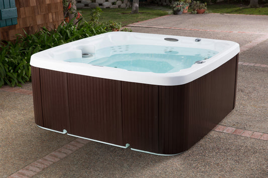Hot tub with brown exterior and white interior on a paved surface.