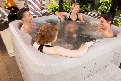 Four people enjoying a hot tub in an outdoor setting